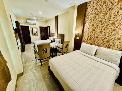 a hotel room with a bed and a table and chairs at Shelton Hotel Lahore in Lahore