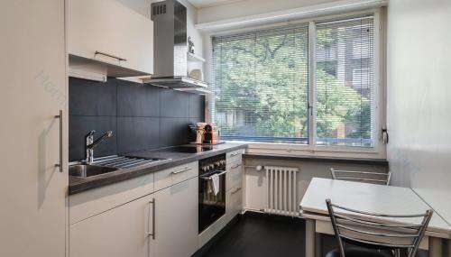 Il comprend une cuisine équipée d'un évier et d'une cuisinière. four supérieur dans l'établissement Athénée 40 Residence by Homenhancement, à Genève