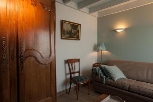 a living room with a couch and a chair at Domein Het Weiland in Damme