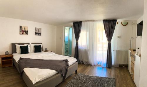 a bedroom with a bed and a large window at Casa TOR - Moieciu de Jos in Moieciu de Jos