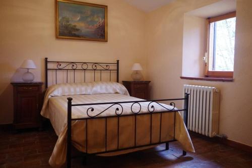 a bedroom with a bed and two night stands with two lamps at Rustico appartamento in tenuta agricola - Umbria in San Valentino