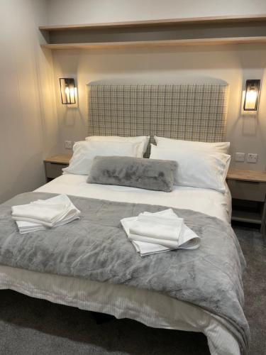 a bedroom with a bed with two towels on it at The Drey in Grantown on Spey