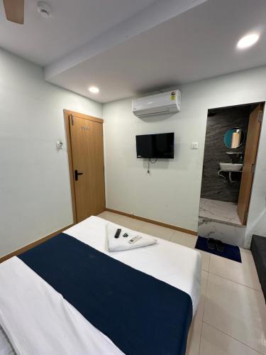 Habitación de hotel con cama y TV en Hotel sky palace adajan, en Surat