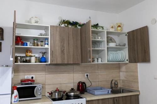 a kitchen with wooden cabinets and a microwave at Stavroula's Houses in Kélla