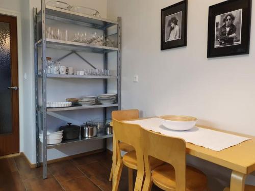 una mesa de comedor con sillas y un estante con platos en Cozy completely renovated flat (sis. Alv), en Kajaani