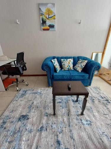 a living room with a blue couch and a table at LaMeg Homestay in Nairobi