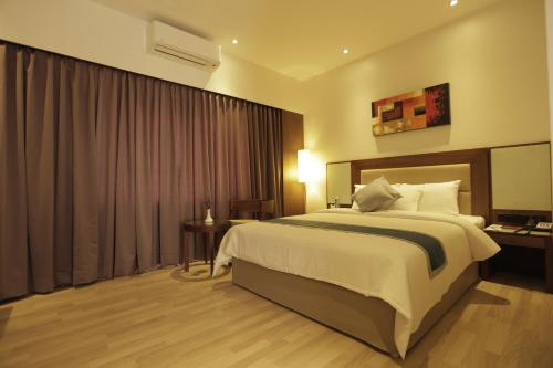 una camera d'albergo con un grande letto e una finestra di Park Connect a Cochin