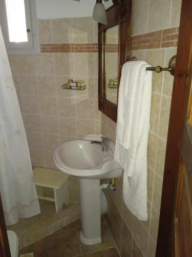 a bathroom with a white sink and a mirror at Lesvos Tower House Komninos in Sígrion