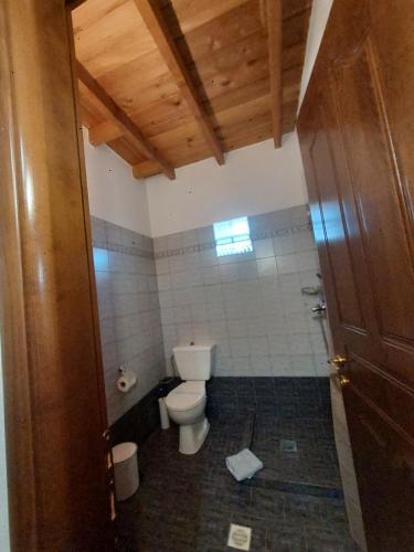 a small bathroom with a toilet and a window at Guesthouse Platon in Órma
