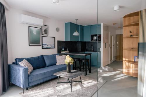 a living room with a blue couch and a table at Home From Home - Kraków, Podgórze in Kraków