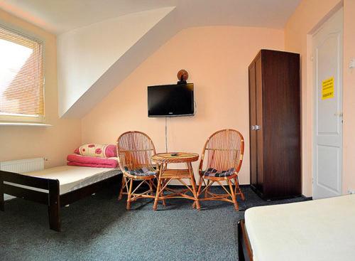 キェルツェにあるTanie Noclegi Bartekのベッド、テーブル、椅子が備わる客室です。