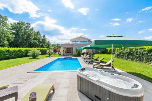 een zwembad met een jacuzzi in de tuin bij Villa Fantasia for 8 people with jacuzzi and private pool in Hreljići
