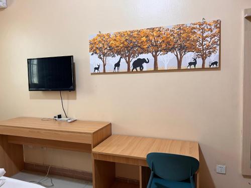 a room with a desk and a painting of elephants on the wall at ROYAL HOTEL in Juba