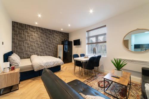 a living room with a couch and a bed and a table at Orange Rentals- Studio apartment in the city centre of Liverpool in Liverpool
