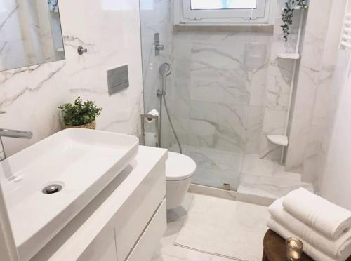 La salle de bains blanche est pourvue d'un lavabo et de toilettes. dans l'établissement Garden 63 - Jardim da Parada - Campo de Ourique, à Lisbonne