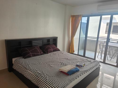 1 dormitorio con 1 cama con 2 toallas en Jomtien Hill Resort Pratamnak en Pattaya South