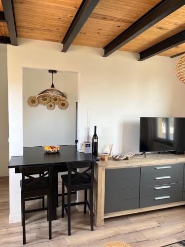 une cuisine avec une table noire et des chaises noires dans l'établissement Rayon de soleil, à La Baule