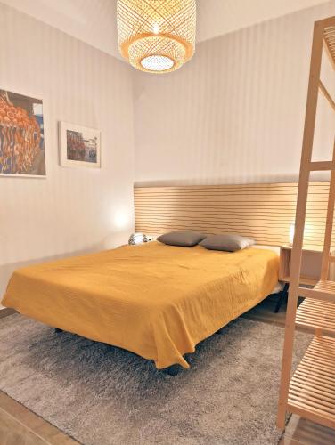 a bedroom with a large bed with a yellow bedspread at Santa Cruz Ocean Apartment - II in Santa Cruz