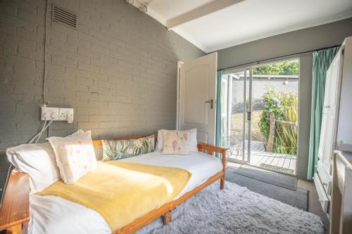 a bedroom with a bed and a large window at A Stone's Throw Accommodation in Grahamstown