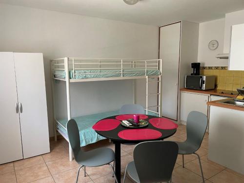 een kleine kamer met een tafel en een stapelbed bij Grand studio 3 50m de la plage in Argelès-sur-Mer