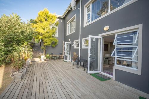 a house with a wooden deck in front of it at A Stone's Throw Accommodation in Grahamstown