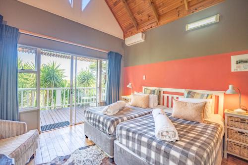 a bedroom with two beds and a large window at A Stone's Throw Accommodation in Grahamstown