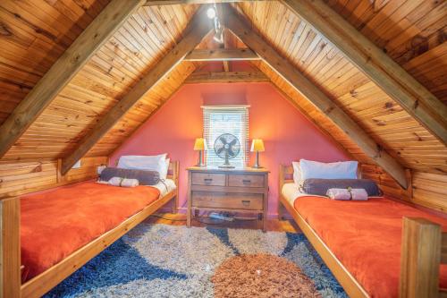 two beds in a room with a attic at A Stone's Throw Accommodation in Grahamstown