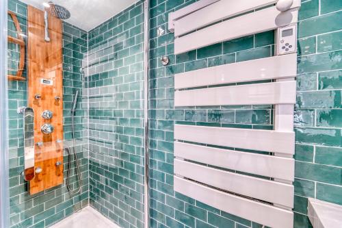 a bathroom with green tiled walls and a shower at Chic and modern house with parking garden and gym in Saint-Denis