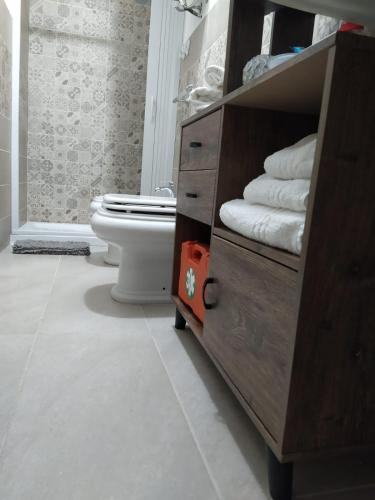 a bathroom with a toilet and a cabinet with towels at L'amuri du mare in Trapani
