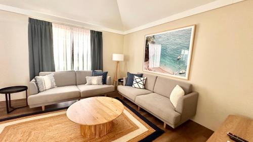 a living room with a couch and a table at Sandblu: Resort Villa on the Beach in Broadwater