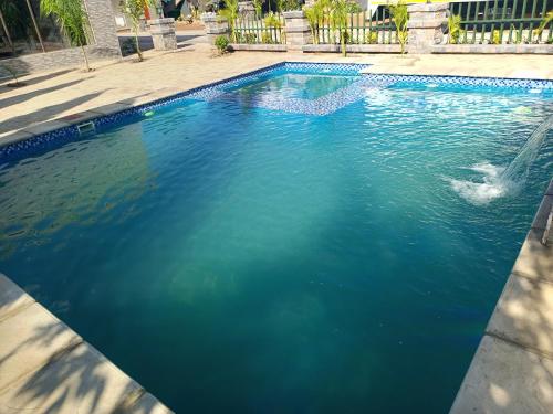 uma piscina de água azul com uma fonte em The Furnished Apartments em Livingstone