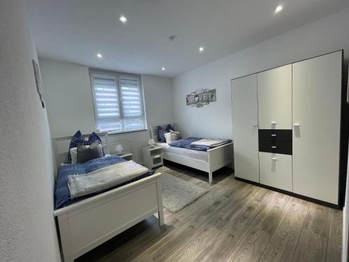 1 dormitorio con 2 camas y un espejo grande en Maria's Ferienwohnung - Modernität trifft Eleganz en Dettingen an der Erms