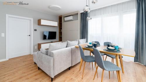 a living room with a couch and a table and chairs at Wonder Home - Domki Hillside tuż przy stoku narciarskim - na terenie kompleksu plac zabaw i zewnętrzna siłownia, sklep, parking in Karpacz