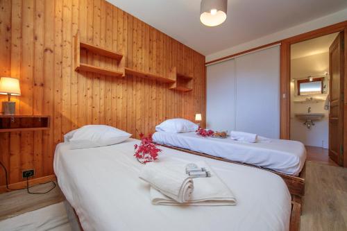 deux lits dans une chambre aux murs en bois dans l'établissement Chalet Charpoua - Happy Rentals, à Chamonix-Mont-Blanc