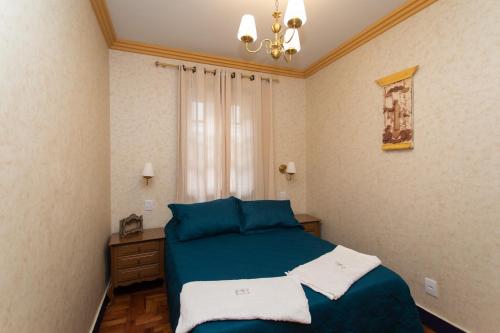Un dormitorio con una cama azul y una ventana en Casa do Beco - Casa Inteira no Centro de Ouro Preto en Ouro Preto