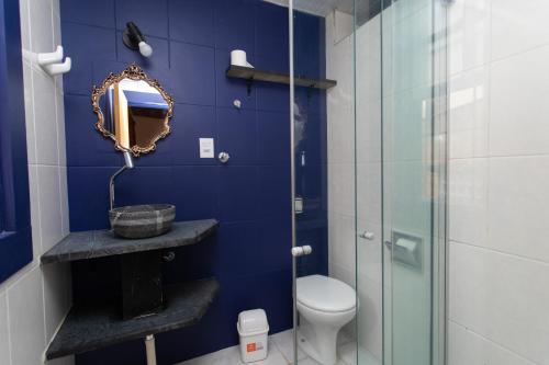 y baño con ducha de cristal y aseo. en Casa do Beco - Casa Inteira no Centro de Ouro Preto en Ouro Preto