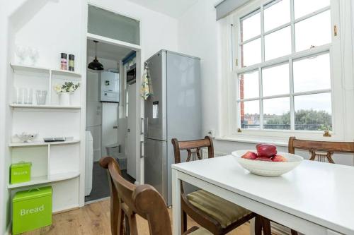 una cocina con una mesa con un bol de fruta. en Central 1 BR Apartment *Zone 1* Elephant and Castle, en Londres