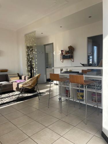a kitchen and living room with a table and chairs at Appart 60 m2 séjour sur terrasse sud et 2 chambres gare Saint-Charles in Marseille