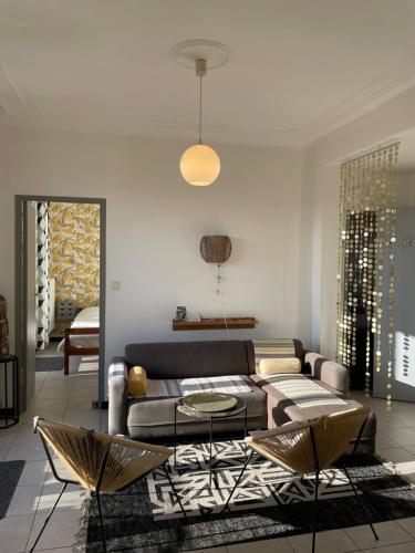 sala de estar con sofá, mesa y sillas en Appart 60 m2 avec terrasse 35m2 séjour sud et 2 vraies chambres gare Saint-Charles en Marsella