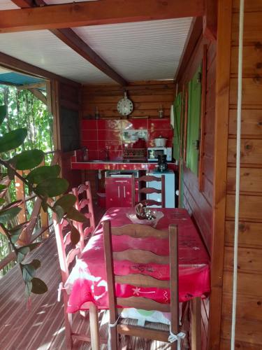 a dining room with a red table and chairs at ankaché in Grand-Bourg