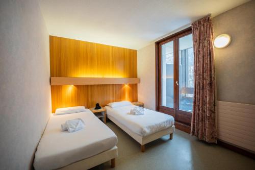 a hotel room with two beds and a window at Azureva Areches in Arêches
