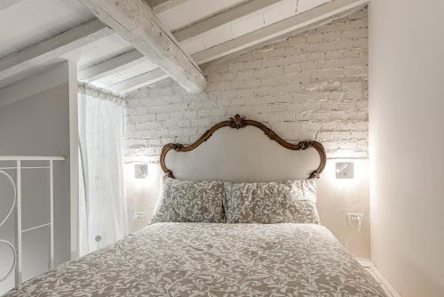 a bedroom with a bed with a white brick wall at Olive Garden Loft - Settignano in Settignano