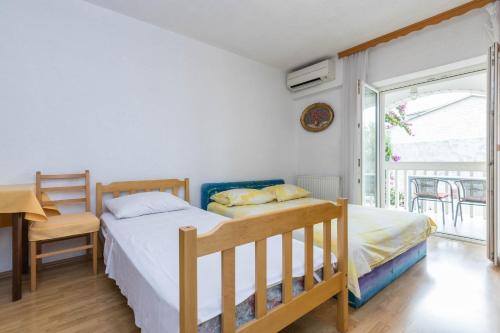 a bedroom with two beds and a balcony at Apartments Cipetic in Kaštela