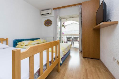 a bedroom with a bed and a television in a room at Apartments Cipetic in Kaštela
