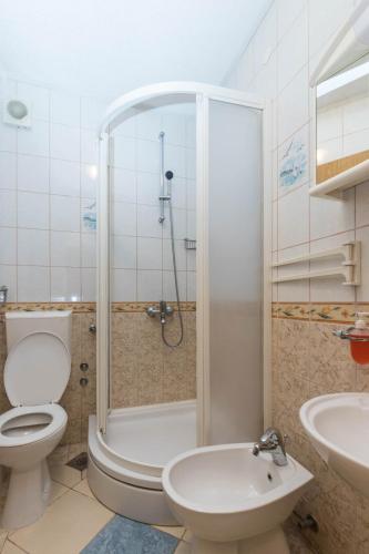 a bathroom with a shower and a toilet and a sink at Apartments Cipetic in Kaštela