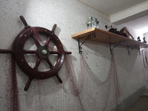 a wooden steering wheel on a wall with a shelf at L'amuri du mare in Trapani