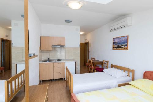 a room with two beds and a kitchen at Apartments Cipetic in Kaštela