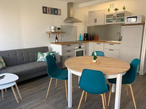 une cuisine et un salon avec une table et des chaises dans l'établissement Bel appart avec terrasse tout proche plage, à Saint-Cyprien