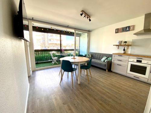 une cuisine et un salon avec une table et des chaises dans l'établissement Bel appart avec terrasse tout proche plage, à Saint-Cyprien