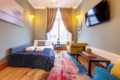 ロンドンにある2 Bedroom in Center of Londonのベッド1台とソファが備わる小さな客室です。